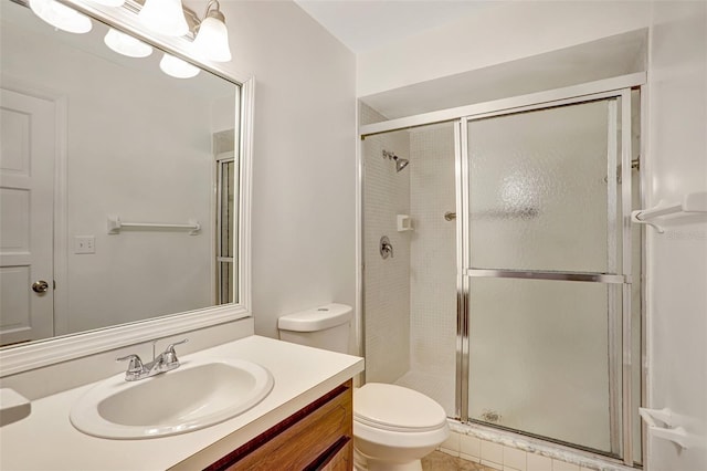 bathroom featuring tile patterned flooring, toilet, vanity, and walk in shower