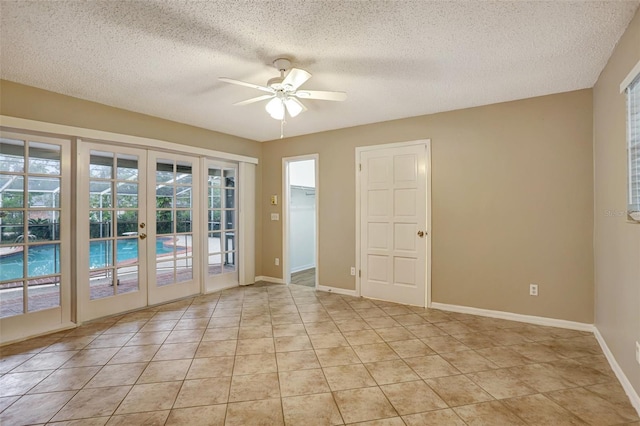 tiled spare room with ceiling fan, french doors, and a textured ceiling