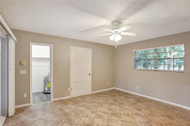 unfurnished bedroom with light tile patterned floors, a textured ceiling, ceiling fan, and water heater