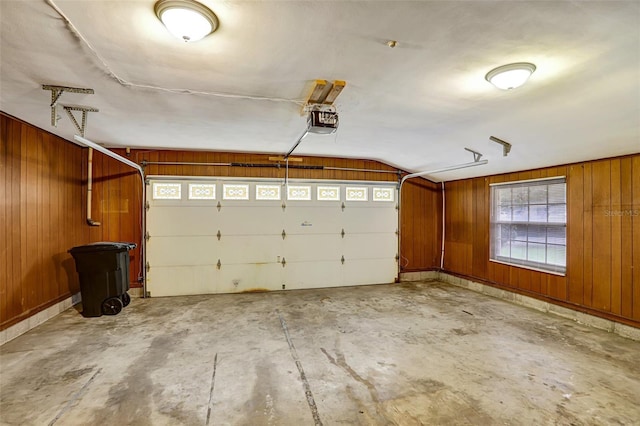 garage with wood walls and a garage door opener