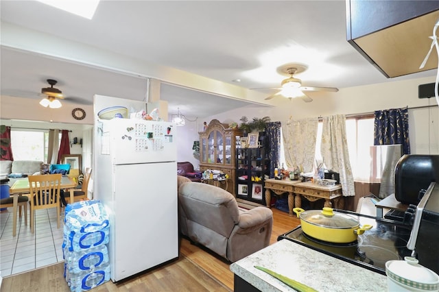 kitchen with ceiling fan, white fridge, and light hardwood / wood-style flooring