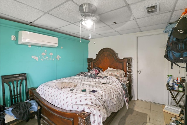 bedroom featuring a wall mounted air conditioner, ceiling fan, a paneled ceiling, and tile patterned flooring