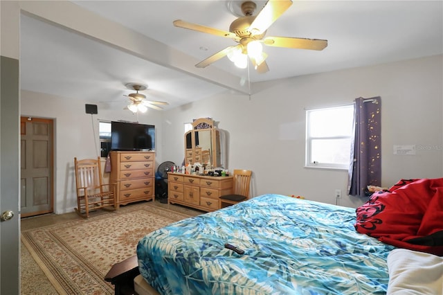 carpeted bedroom with beam ceiling and ceiling fan