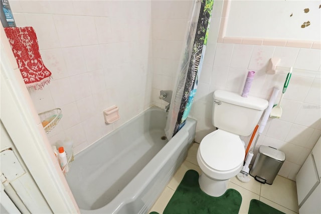 bathroom featuring tile patterned floors, shower / bathtub combination with curtain, tile walls, and toilet