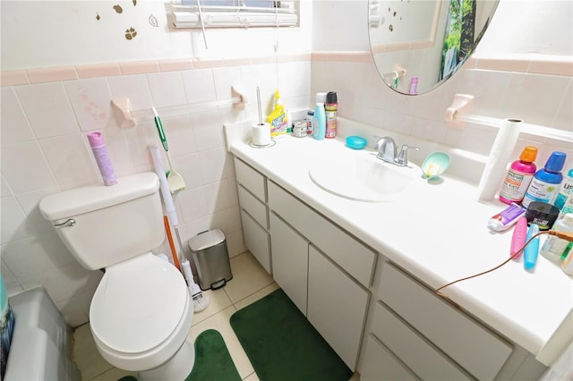 bathroom featuring tile patterned flooring, vanity, tile walls, and toilet