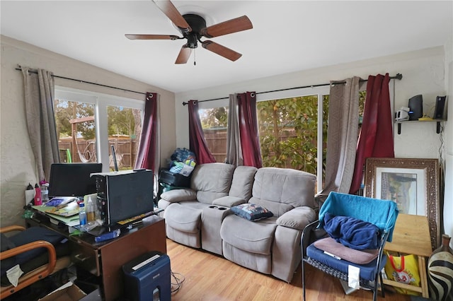 living room featuring ceiling fan, light wood-type flooring, and vaulted ceiling