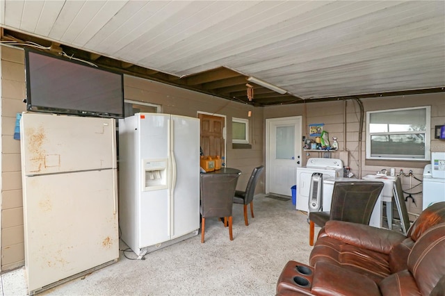 kitchen with white fridge with ice dispenser, white fridge, and washer and dryer