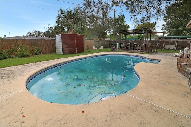 view of pool featuring a storage unit and a patio area