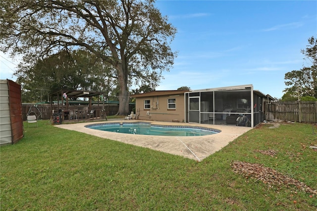 view of pool with a sunroom, a yard, and a patio