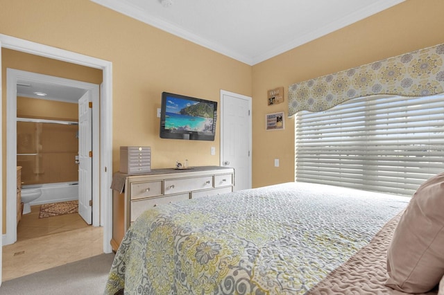 carpeted bedroom with ensuite bathroom and crown molding