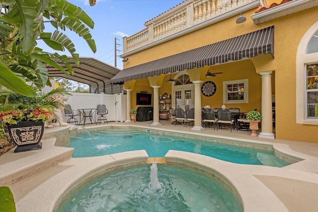 view of swimming pool featuring pool water feature, a patio area, and an in ground hot tub