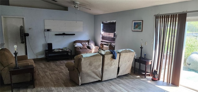 living room with ceiling fan, wood-type flooring, a textured ceiling, and vaulted ceiling