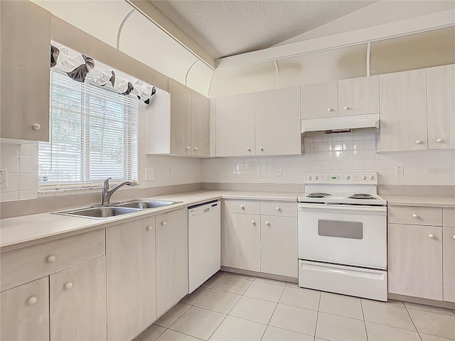 kitchen with sink, a textured ceiling, lofted ceiling, white appliances, and light tile patterned floors