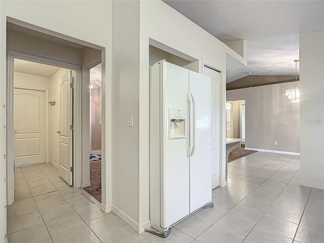 hall with light tile patterned flooring, a chandelier, and lofted ceiling