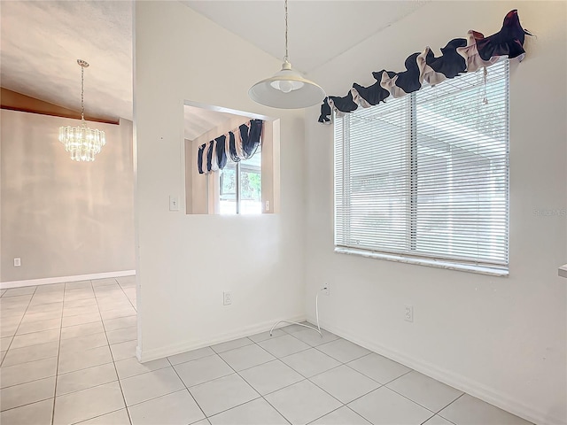 tiled empty room featuring vaulted ceiling and a notable chandelier