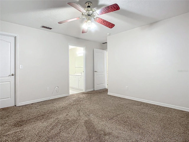 empty room with ceiling fan, carpet floors, and a textured ceiling