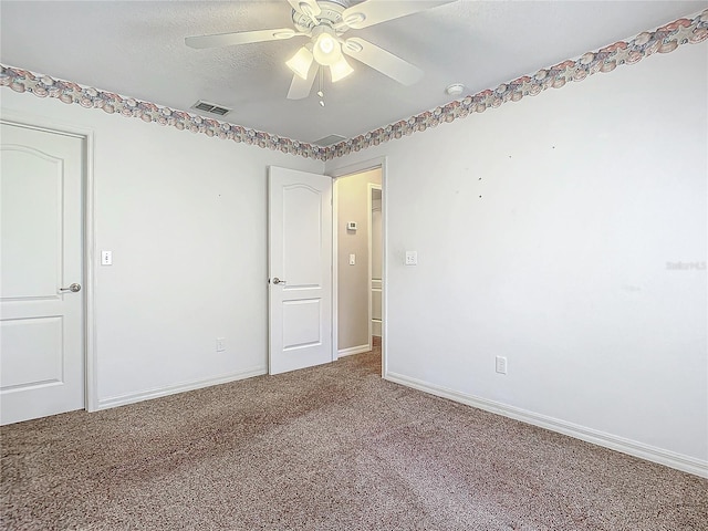 carpeted empty room featuring a textured ceiling and ceiling fan