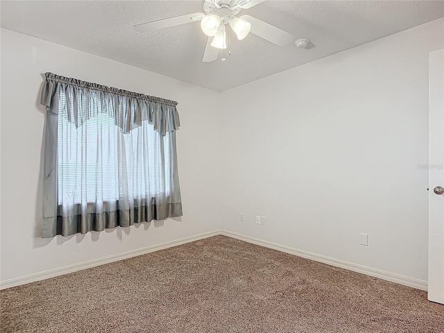 spare room with a textured ceiling, carpet floors, and ceiling fan