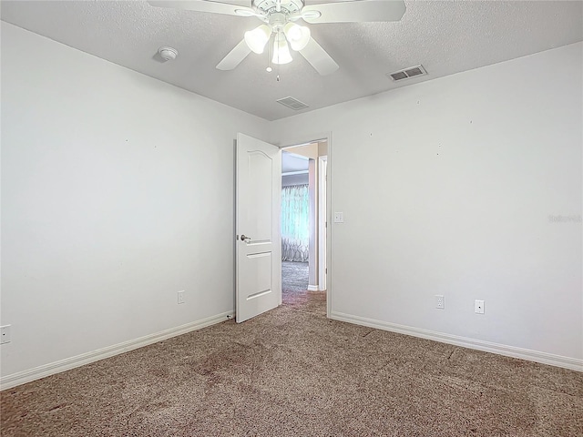 spare room featuring carpet flooring, ceiling fan, and a textured ceiling