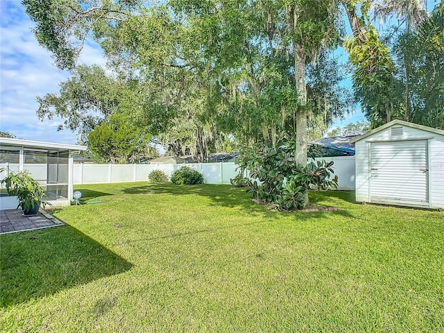 view of yard with a sunroom and a storage shed