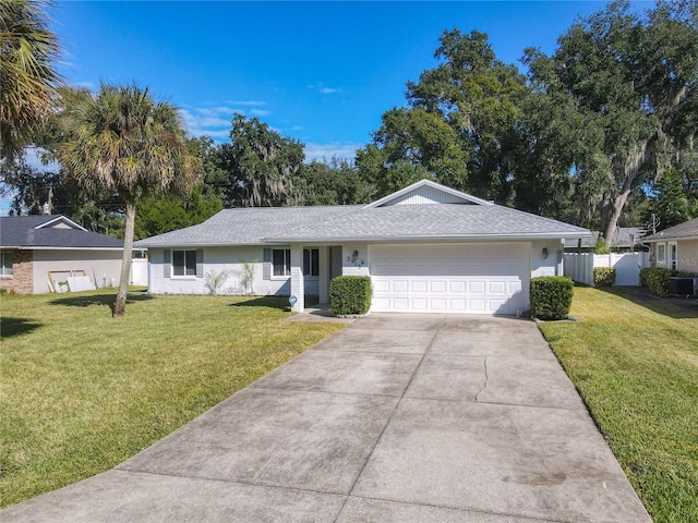 ranch-style home with a front yard, a garage, and cooling unit