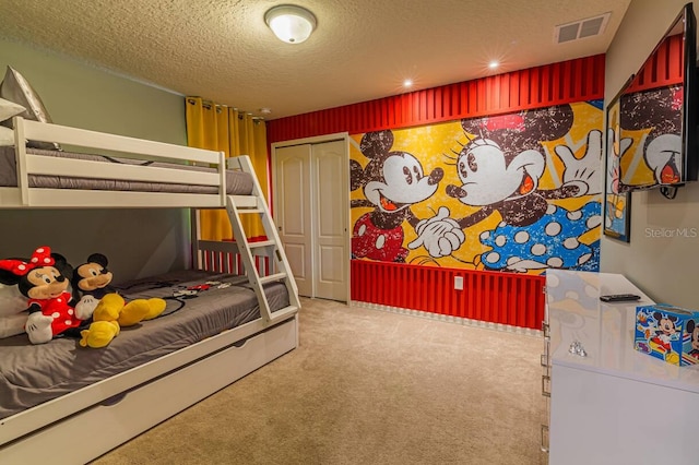 carpeted bedroom with a textured ceiling and a closet