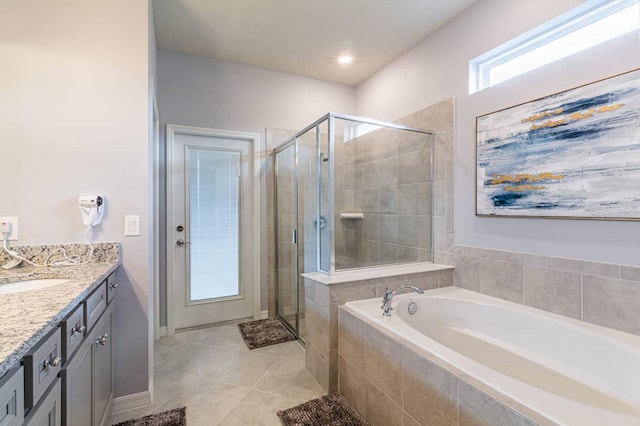 bathroom with plus walk in shower, vanity, and tile patterned flooring