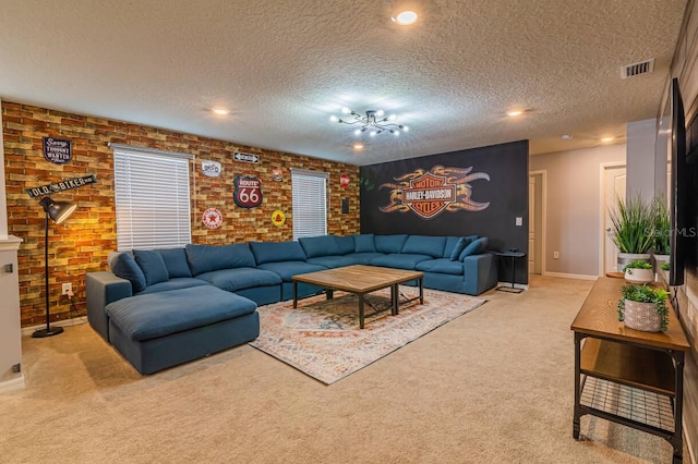 living room featuring light carpet, brick wall, a textured ceiling, and a notable chandelier