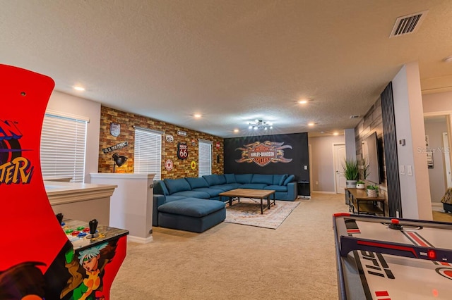 recreation room featuring light colored carpet and a textured ceiling