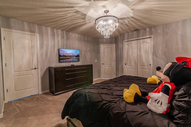 carpeted bedroom featuring a textured ceiling and an inviting chandelier