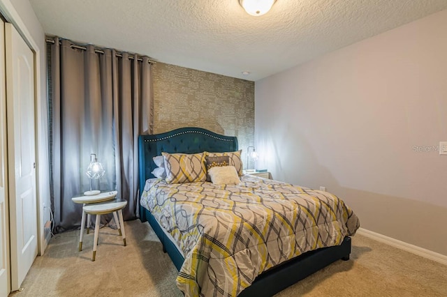 carpeted bedroom with a textured ceiling and a closet