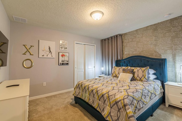 bedroom featuring carpet, a textured ceiling, and a closet