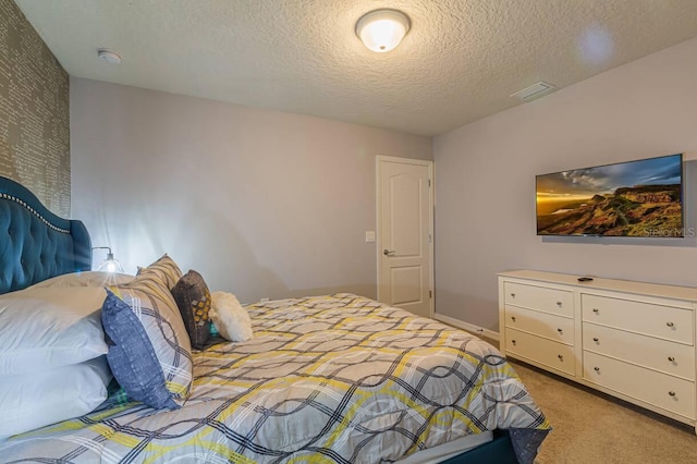 bedroom with light carpet and a textured ceiling