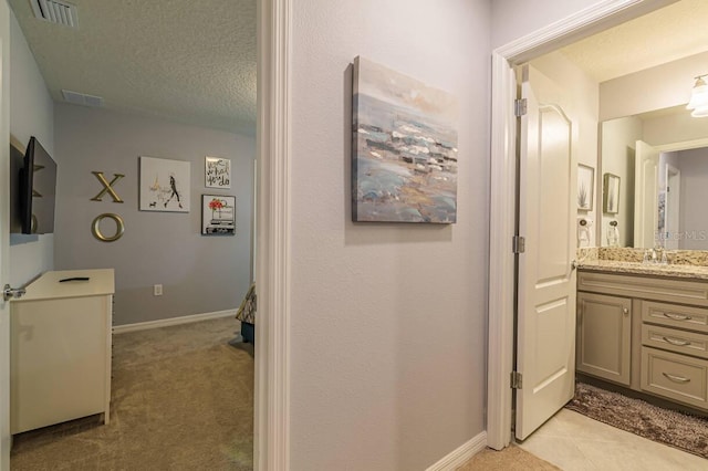 7400 Oakmoss Loop, Davenport, FL 33837 - bathroom with a textured ceiling, vanity, and baseboards