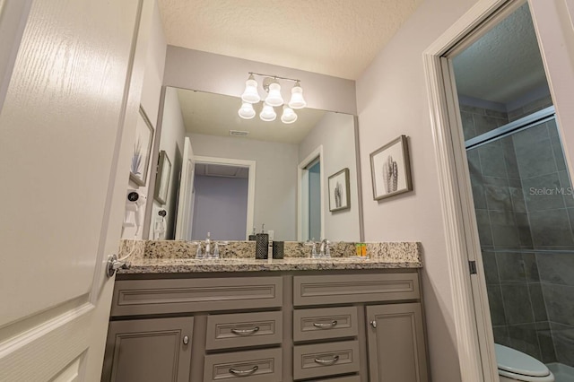 7400 Oakmoss Loop, Davenport, FL 33837 - full bath with tiled shower, double vanity, toilet, a chandelier, and a textured ceiling