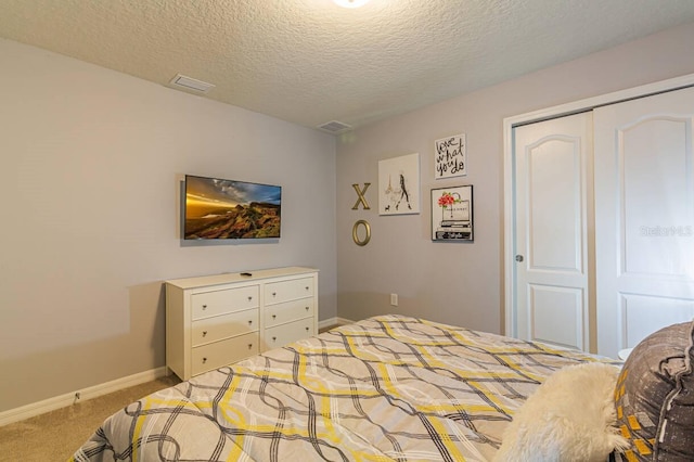 bedroom with light carpet, a textured ceiling, and a closet