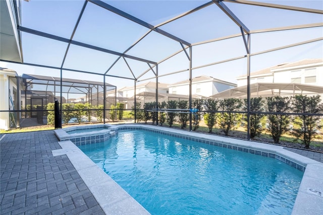 view of pool with a patio and glass enclosure