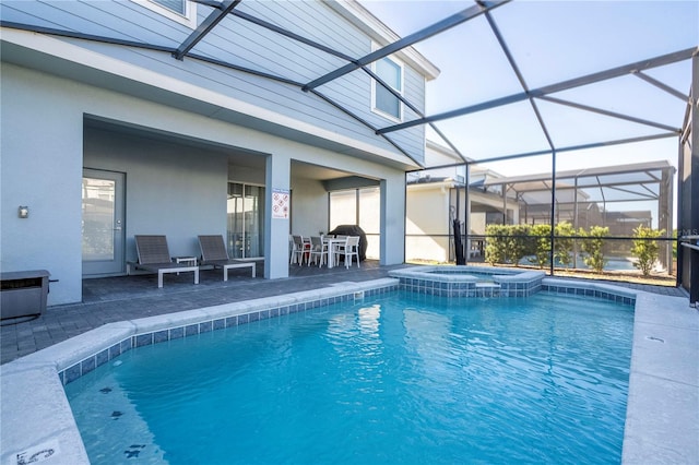 view of pool featuring an in ground hot tub, a patio, and glass enclosure