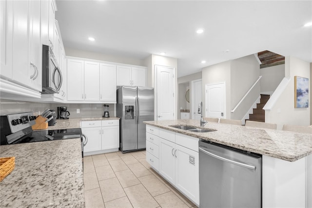 kitchen featuring a center island with sink, white cabinetry, sink, and appliances with stainless steel finishes