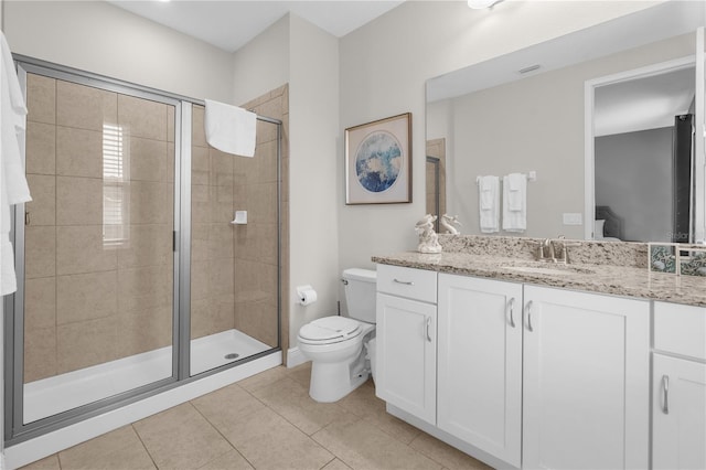 bathroom featuring tile patterned flooring, vanity, a shower with door, and toilet