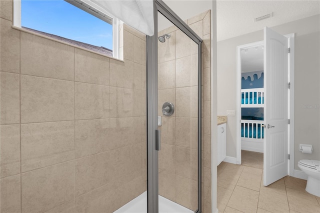 bathroom featuring tile patterned floors, a shower with shower door, a textured ceiling, and toilet