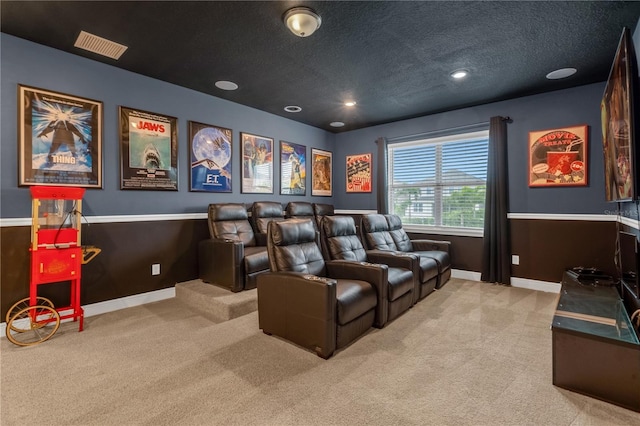 home theater room featuring light colored carpet and a textured ceiling