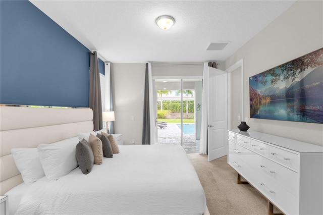 carpeted bedroom featuring access to exterior and a textured ceiling