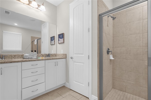 bathroom featuring tile patterned flooring, vanity, and a shower with shower door