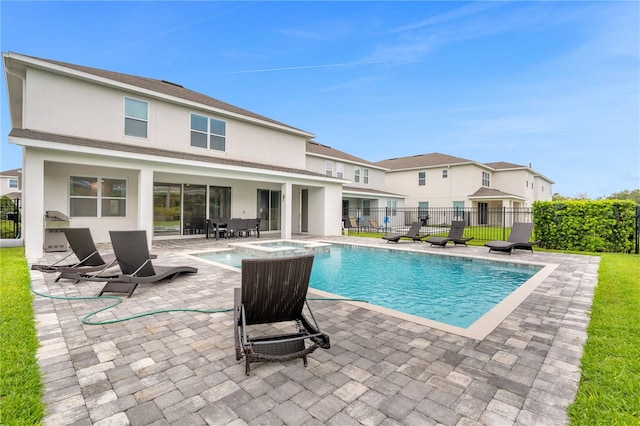 view of pool with an in ground hot tub and a patio area