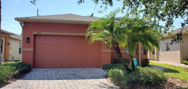 836 Grand Canal Dr, Kissimmee, FL 34759 - view of front of home featuring stucco siding, decorative driveway, and an attached garage