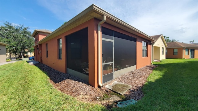 view of property exterior featuring a lawn and a sunroom