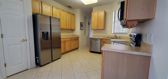 836 Grand Canal Dr, Kissimmee, FL 34759 - kitchen featuring appliances with stainless steel finishes, a sink, light countertops, light tile patterned floors, and light brown cabinets