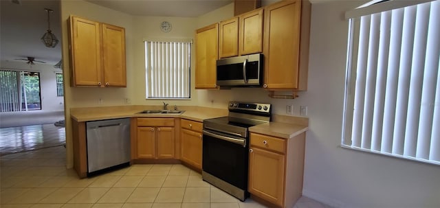 kitchen with sink, hanging light fixtures, ceiling fan, light tile patterned flooring, and stainless steel appliances