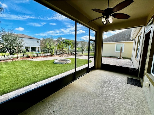 unfurnished sunroom with ceiling fan